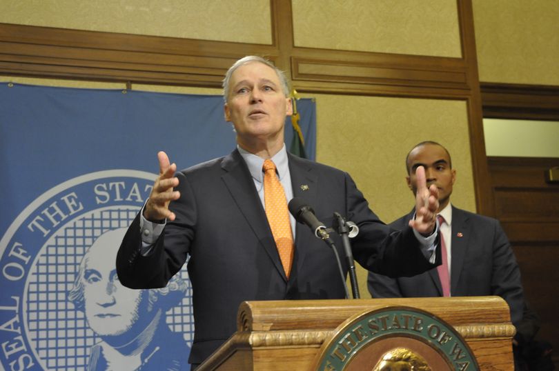 OLYMPIA -- Gov. Jay Inslee, with his chief legal council Nick Brown, discusses an executive order restricting state agencies from inquiring about the residency status of people who seek services or come into contact with state or local law enforcement.  (Jim Camden/The Spokesman-Review)