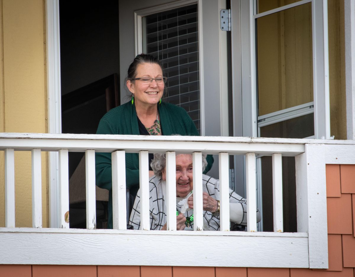 Friends and family of 97-year-old Margaret Presley serenaded her with Irish songs Tuesday while she listened from a balcony at the South Hill Village. She is currently semi-quarantined in the assisted-living community. (Colin Mulvany / The Spokesman-Review)