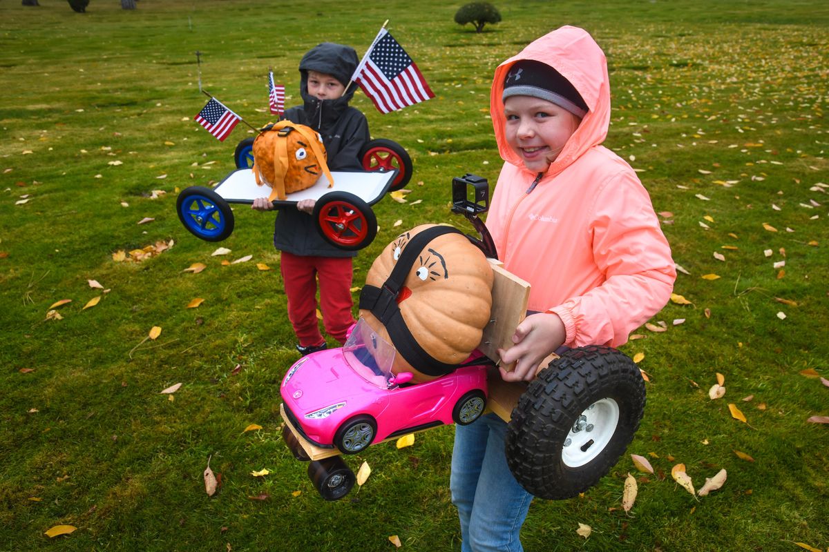 Jaren Stottlemyre, 8, right, brought her “Big Lips” vehicle and her step brother, Jax Van Keulen, 9, carries his “American Warrior” entry to the 9th Annual Great Pumpkin Race, Saturday, Oct. 26, 2019, at Greenwood Memorial Terrace Cemetery, in Spokane, Wash. (Dan Pelle / The Spokesman-Review)