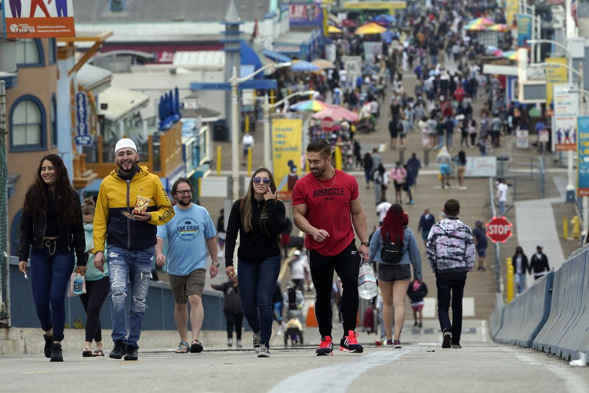 Visitors walk without masks on May 13 on the pier in Santa Monica, Calif.  (Marcio Jose Sanchez)
