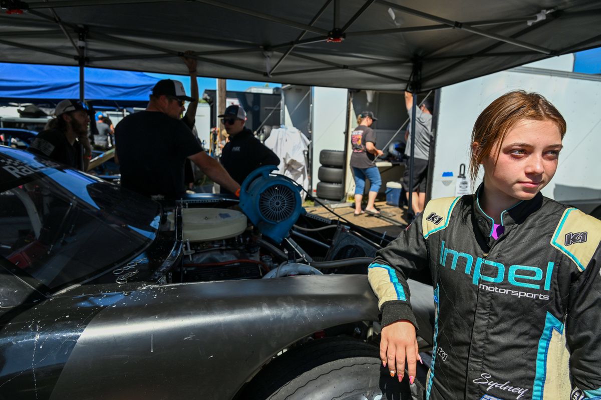 Hanging out in the pit area, Sydney Hamlin, 16, leans against the No. 27 Pro Late Model car on July 25 at Stateline Speedway before the Idaho 200. (Jesse Tinsley/The Spokesman-Review)