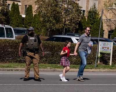 A parent walks with their child from Woodmont Baptist Church where children were reunited with their families after a mass shooting at The Covenant School on March 27, 2023, in Nashville.  (Seth Herald)
