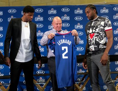 Los Angeles Clippers team chairman Steve Ballmer, center, presents a new team jersey to Kawhi Leonard, right, as Paul George looks on during a press conference in Los Angeles, Wednesday, July 24, 2019. Nearly three weeks after the native Southern California superstars shook up the NBA by teaming up with the Los Angeles Clippers, the dynamic duo makes its first public appearance. (Ringo H.W. Chiu / Associated Press)