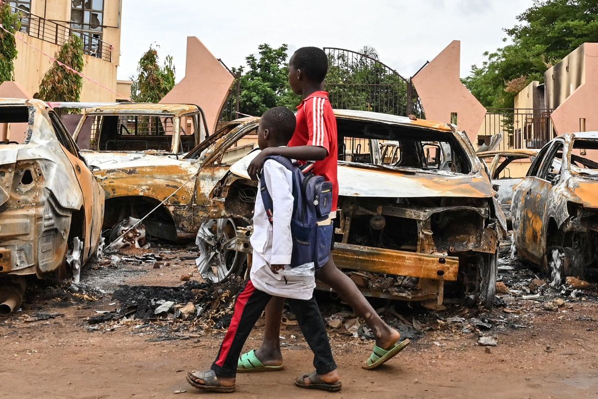 Children walk past burned cars outside the headquarters of President Mohamed Bazoum’s Nigerien Party for Democracy and Socialism in Niamey on Monday. Niger’s military rulers on Monday defied an ultimatum to restore the elected government as the threat of possible military intervention was still on the table. (tribune news service)