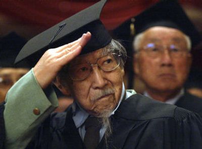 
Minoru Ito, 80, salutes as he listens to the national anthem during a graduation ceremony in Los Angeles on Sunday. 
 (Associated Press / The Spokesman-Review)