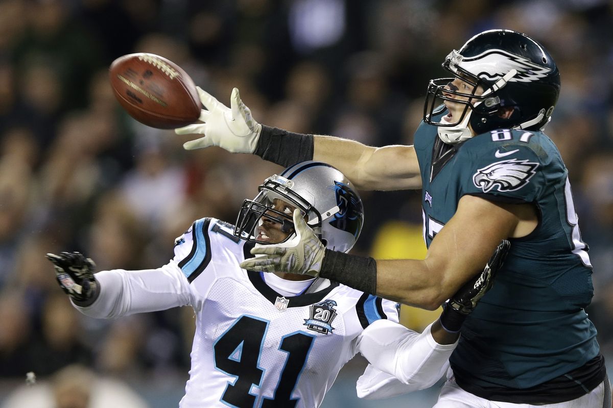 Philadelphia’s Brent Celek goes over Carolina’s Roman Harper to pull in a second-half pass in the Eagles’ 45-21 victory. (Associated Press)