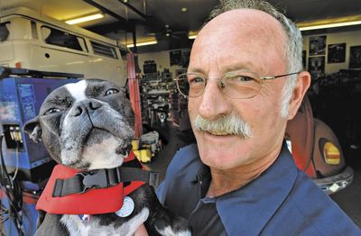 Pete Pollard poses with his dog, Ali, in Medford, Ore., on Tuesday. Ali is wearing the life jacket that saved his life after a rafting accident near Agness, Ore.  (Associated Press / The Spokesman-Review)