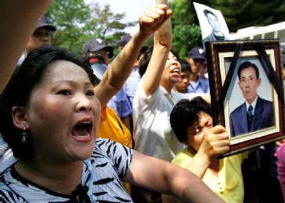 
Members of a group that brings attention to those abducted by North Korea during the 1950-53 Korean War, hold portraits of family members and shout slogans outside the site of South and North Korea meetings in Seoul, today. 
 (Associated Press / The Spokesman-Review)