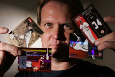 
Mike Mittrick, who operates the 52 Mantle Card store in Brea, Calif., displays baseball trading cards in his shop last month. Faced with declining revenues over the past decade, the baseball card industry has been halved in a matter of months.
 (Associated Press photos / The Spokesman-Review)