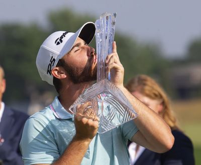 Matthew Wolff kisses the trophy after winning the 3M Open golf tournament Sunday, July 7, 2019, in Blaine, Minn. (Andy Clayton-King / Associated Press)