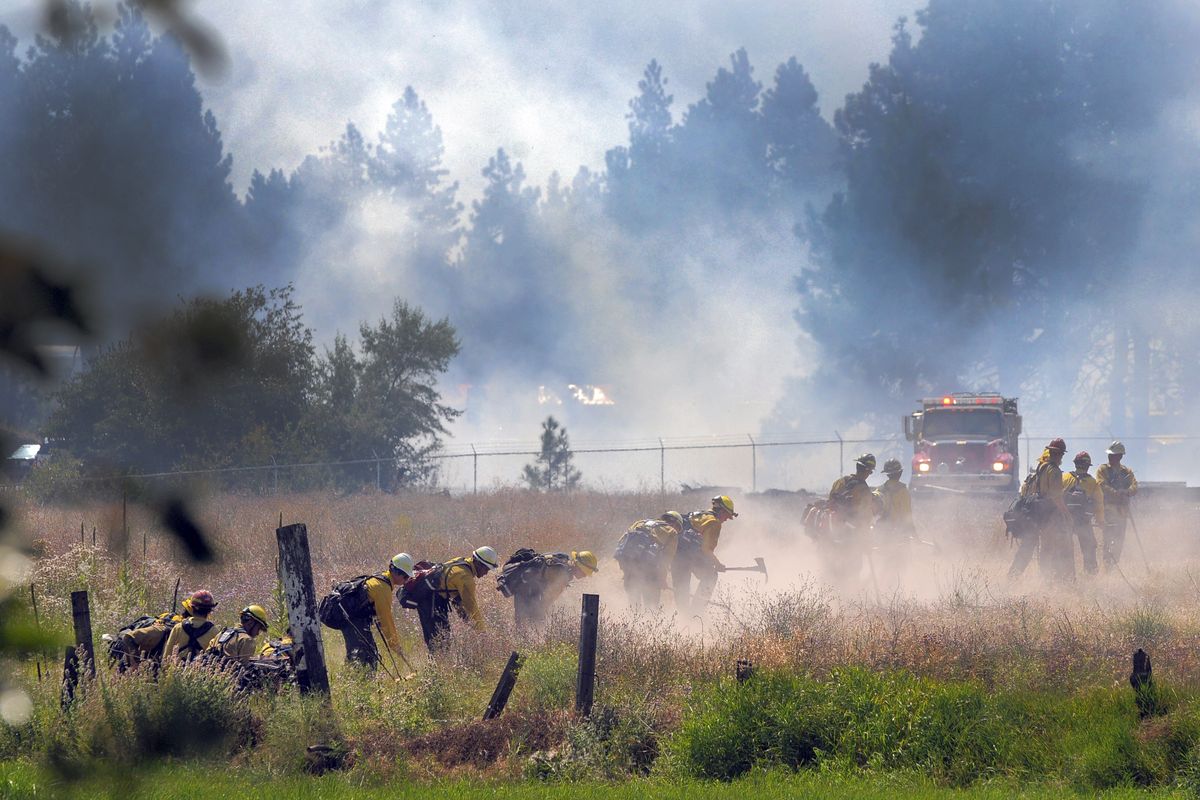 Firefighters kick up dust as they build a fire line around a brush-and-timber fire west of Spokane on Monday, Aug. 10, 2009. (Christopher Anderson / The Spokesman-Review)