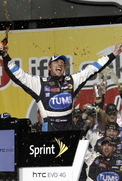 NASCAR driver David Reutimann celebrates with his crew members in Victory Lane on Saturday. (Associated Press)