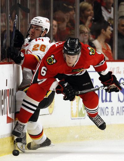 Chicago Blackhawks’ Jordan Hendry, right, battles for the puck with Calgary Flames’ Ales Kotalik during Chicago’s 4-1 win.  (Associated Press)