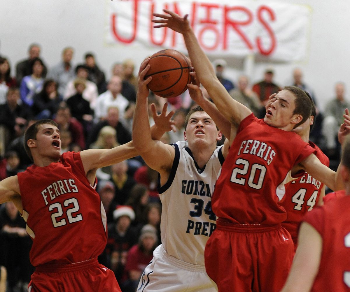 Gonzaga Prep’s Charlie Hopkins (34) grabs a rebound between Ferris’ Jason Bates (22) and Chris Wilson (20) in the first half of Bullpups win. (Colin Mulvany)
