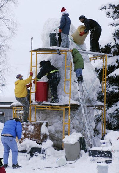 The Powers family, with help from neighbors, work on construction of a giant snowman in their yard in Anchorage, Alaska, on Sunday.
(Associated Press / The Spokesman-Review)