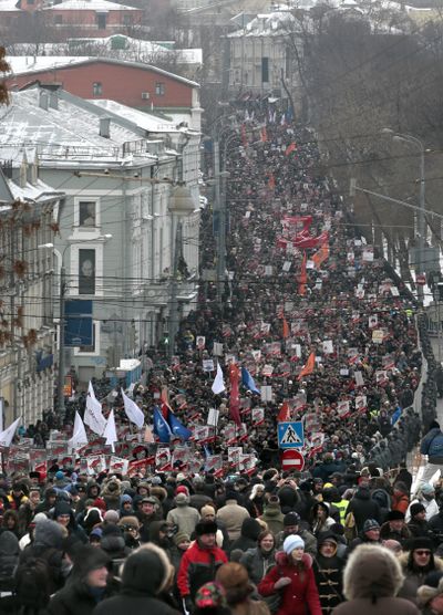 Thousands of people march in central Moscow to protest against Russia's new law banning Americans from adopting Russian children on Sunday. (Associated Press)