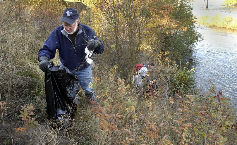 Volunteers participate in the Spokane River Clean-Up in Peaceful Valley in 2003. (File)