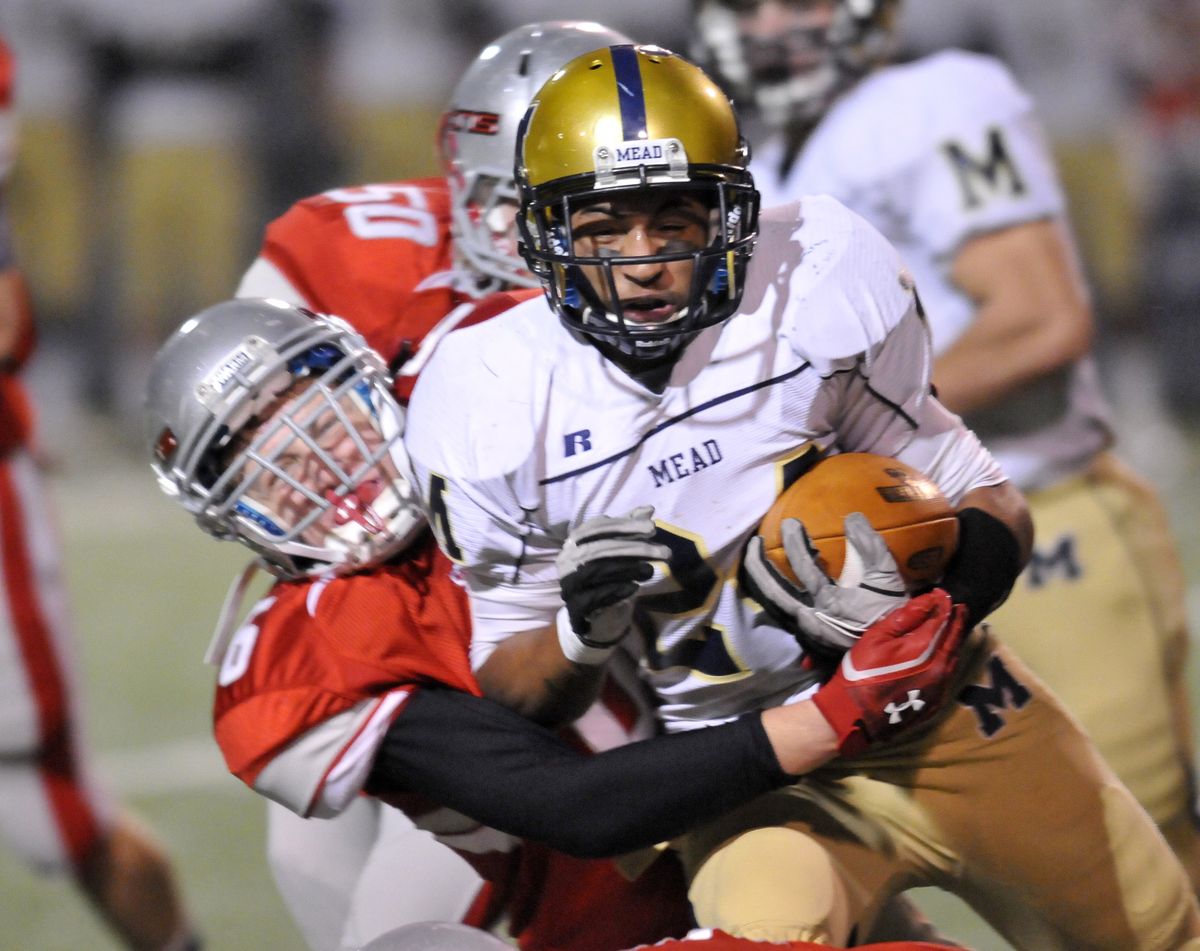 Mead’s Davian Barlow drags Ferris’ Zach Minnerly. Barlow scored four touchdowns despite an injured ankle. (Jesse Tinsley)