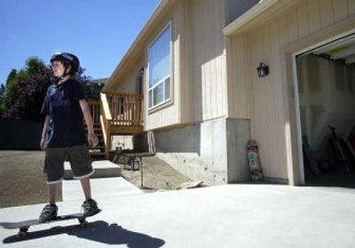 
Taylor Albert, 12, skateboards in the new driveway of his home on Bowdish Road. The Albert home was destroyed by a large pine tree during a windstorm in June 2005. 
 (Liz Kishimoto / The Spokesman-Review)