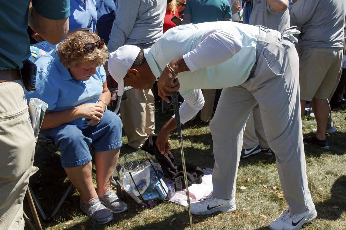 Tiger Woods reaches in to a fan’s bag after his approach shot on the ninth hole landed in it during the second round of the Valspar Championship golf tournament Friday, March 9, 2018, in Palm Harbor, Fla. (Mike Carlson / Associated Press)