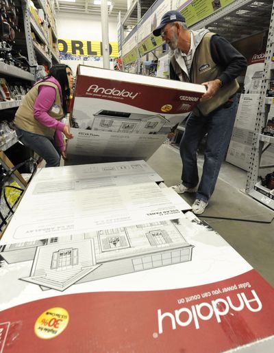 Lowe’s product service associate manager Roxy Ramirez, left, and product service associate Jim Miner stock the first home solar panel system by Andalay at Lowe’s in Los Angeles.  (Associated Press)