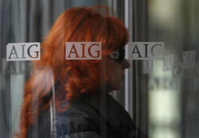 A woman enters an AIG office building  in New York on Monday. American International Group  is under fire over bonuses to its executives despite receiving more than $170 billion in bailout money.  (Associated Press / The Spokesman-Review)