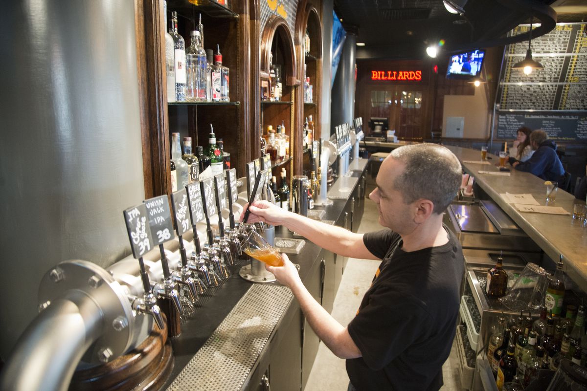 Bill Matthew, produce controller at the North Side Onion, draws a beer from one of 51 taps in the Area 51 Tap House inside the restaurant earlier this week. (Jesse Tinsley)