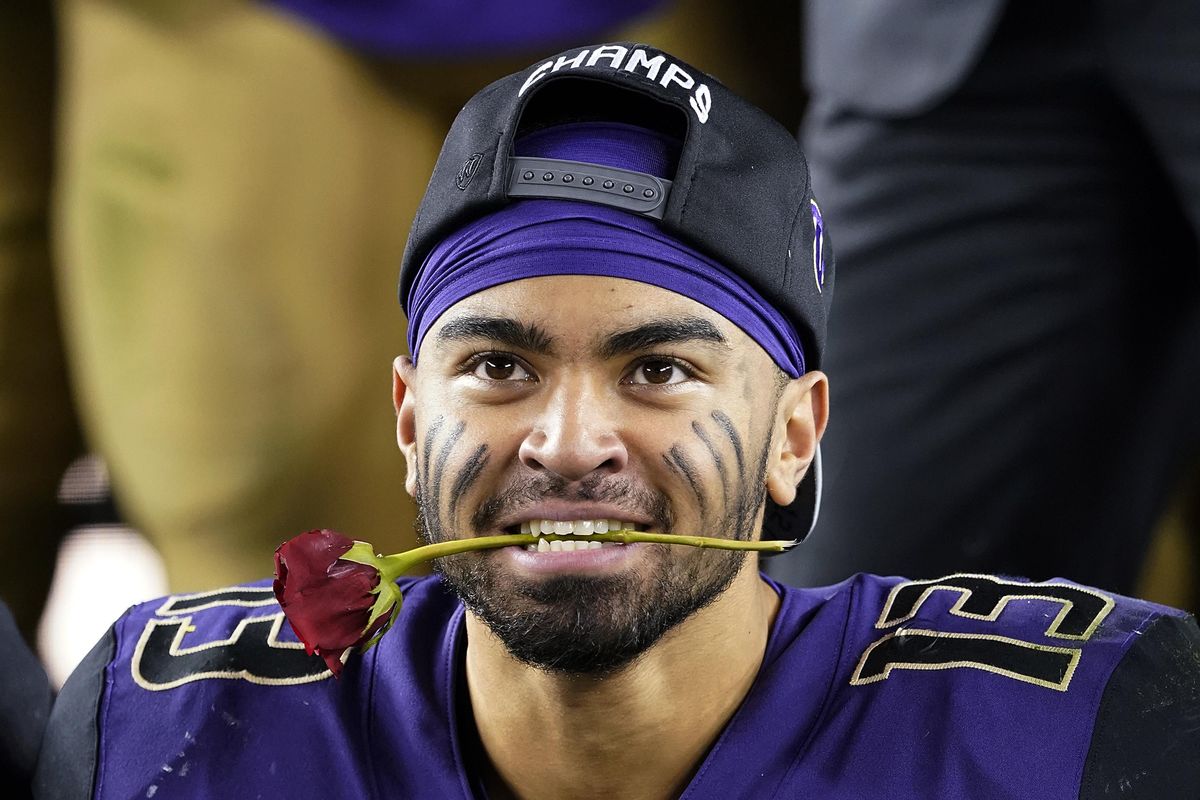 Washington linebacker Brandon Wellington holds a rose in his mouth as he celebrates with teammates after Washington defeated Utah 10-3 in the Pac-12 Conference championship  in Santa Clara, Calif.,  on Nov. 30. (Tony Avelar / AP)