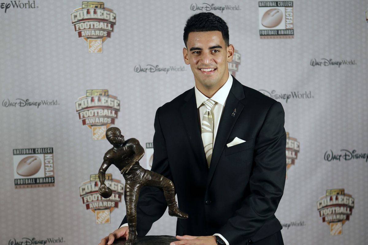 Oregon’s Marcus Mariota stands with his trophy after being awarded the Davey O