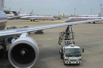 
An American Airlines jet is refueled at the Dallas/Fort Worth International Airport in Grapevine, Texas. To conserve fuel, American in late May began flying trans-Atlantic flights with half as much 