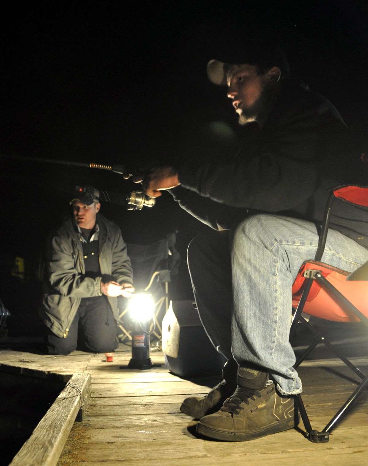 Cory Horntvedt, right, reels in a fish to the encouragement of his stepbrother, Ty Bates, on Saturday morning, April 27, 2013, shortly after the midnight opening of Washington