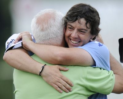 Rory McIlroy hugs his father Gerry on the 18th green after winning the U.S. Open Championship at Congressional Country Club. (Associated Press)