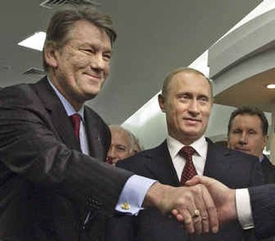 
Russian President Vladimir Putin and Ukrainian President Viktor Yushchenko greet people Saturday in Kiev.
 (Associated Press / The Spokesman-Review)