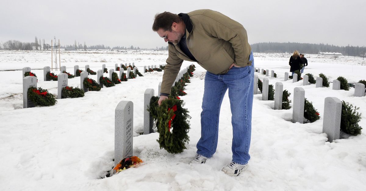Andy Dahlman, of Spokane, lays a wreath on the grave of his son, U.S. Marine Corps Cpl. Joshua Robert Dumaw, on Saturday  at the Washington State Veterans Cemetery  as part of Wreaths Across America. Joshua Dumaw was killed in Afghanistan on June 22 and was awarded the Purple Heart.  (PHOTOS BY DAN PELLE)