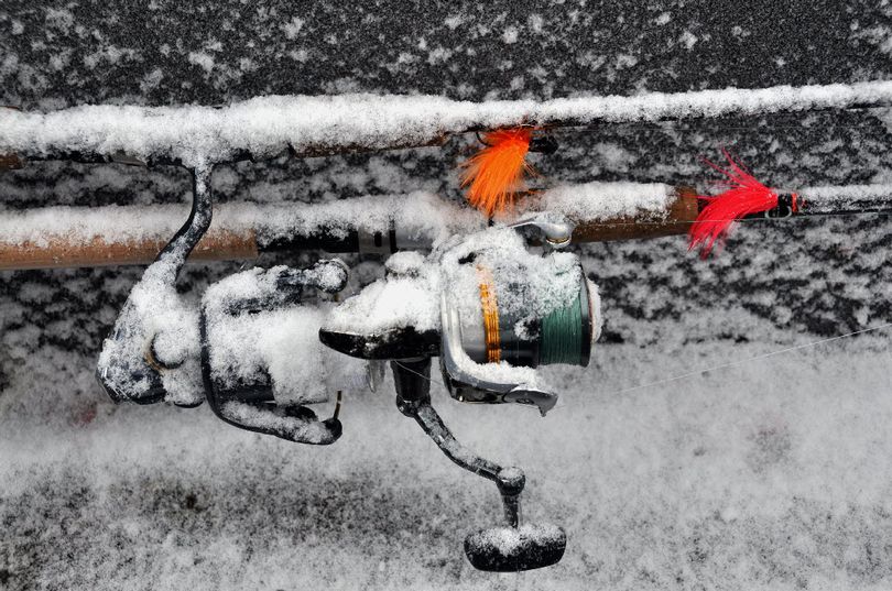 Fishing reels are covered with snow as Jerrod Gibbons of Okanogan Valley Guide Service heads up the Okanogan River to go steelhead fishing during a snow storm in the first week of March. (Rich Landers)