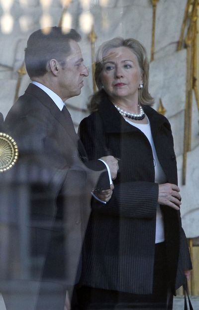 U.S. Secretary of State Hillary Rodham Clinton is seen through the glass of the Elysee Palace with France President Nicolas Sarkozy on Monday. (Associated Press)