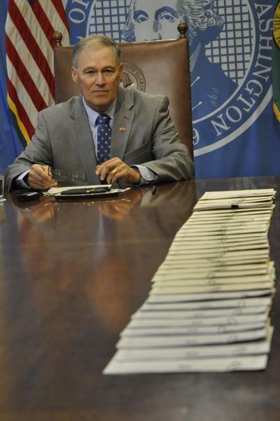 OLYMPIA – Gov. Jay Inslee prepares to sign 32 bills into law, including three changes to state marijuana statutes, Thursday in his conference room. (Jim Camden / The Spokesman-Review)
