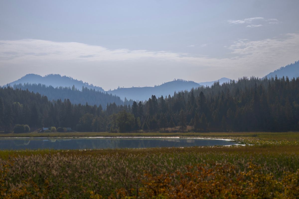 Wildfire smoke settles on the Selkirk Mountains at Porters Lake, just off Highway 3, the White Pines Scenic Byway.  (ANGELA SCHNEIDER/The Spokesman-Review)