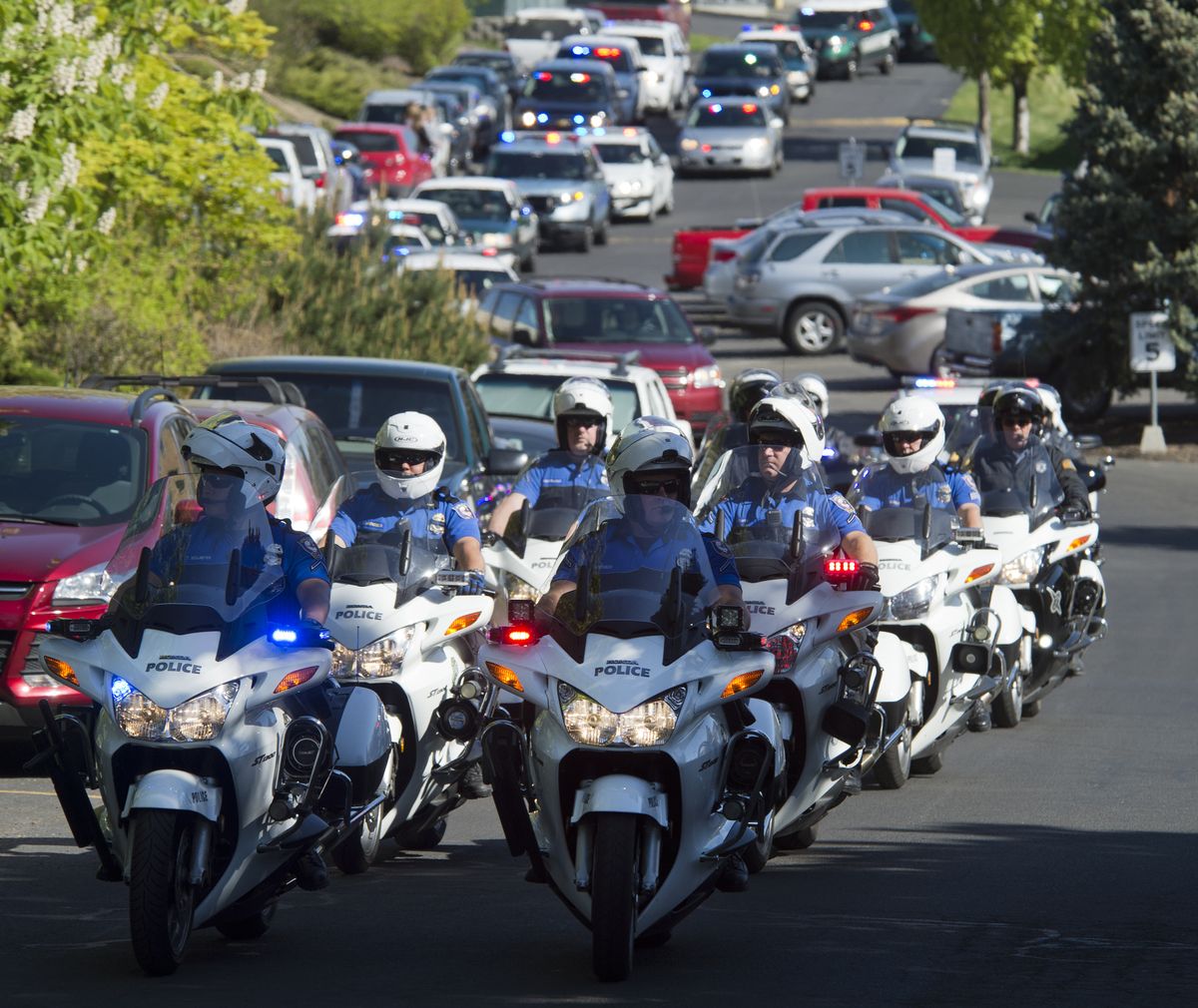 Spokane police officers take the lead in a procession of law enforcement vehicles leaving Holy Family Hospital Thursday morning to escort the body of slain Coeur d’Alene police Sgt. Greg Moore back to Idaho. Services are Saturday. (Dan Pelle)