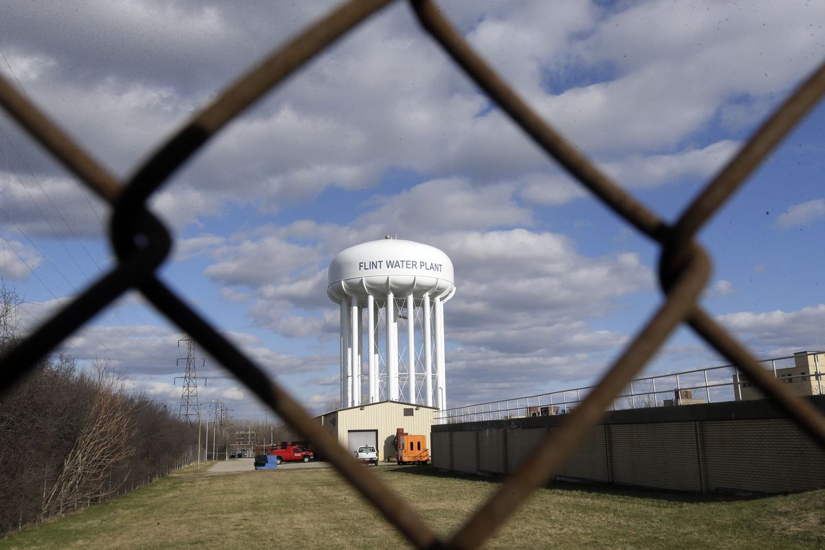 FIL - In this March 21, 2016, file photo the Flint Water Plant water tower is seen in Flint, Mich. Michigan Gov. Gretchen Whitmer says a proposed $600 million deal between the state of Michigan and Flint residents harmed by lead-tainted water is a step toward making amends. Officials announced the settlement Thursday, Aug. 20, 2020, which must be approved by a federal judge. (Carlos Osorio)