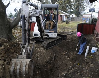 Larry Miller backfills a recently inspected sewer trench in the Spokane Valley while his wife, Melissa, helps shovel dirt. Miller was laid off from his previous job in June 2008, and spent five months unemployed before attending the Avista Center for Entrepreneurship at Spokane Community College.bartr@spokesman.com (J. BART RAYNIAK)