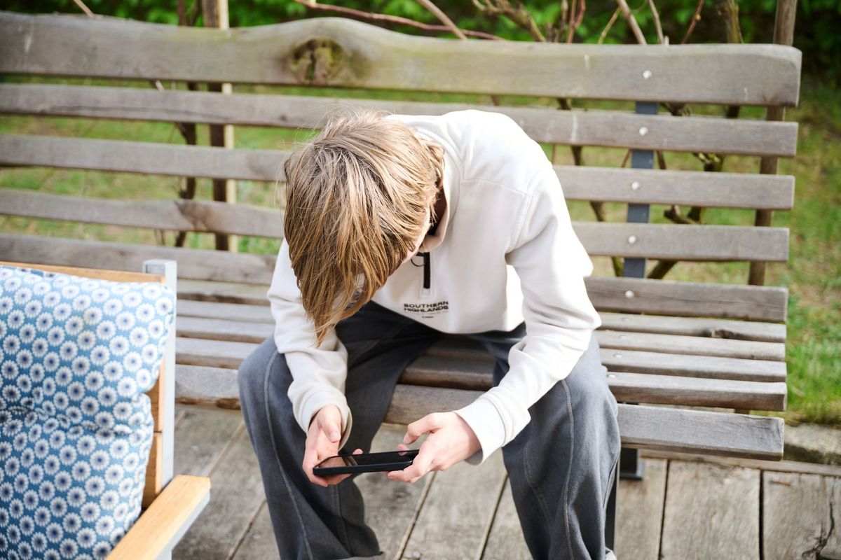 A teen engrossed in his smartphone. Australia
