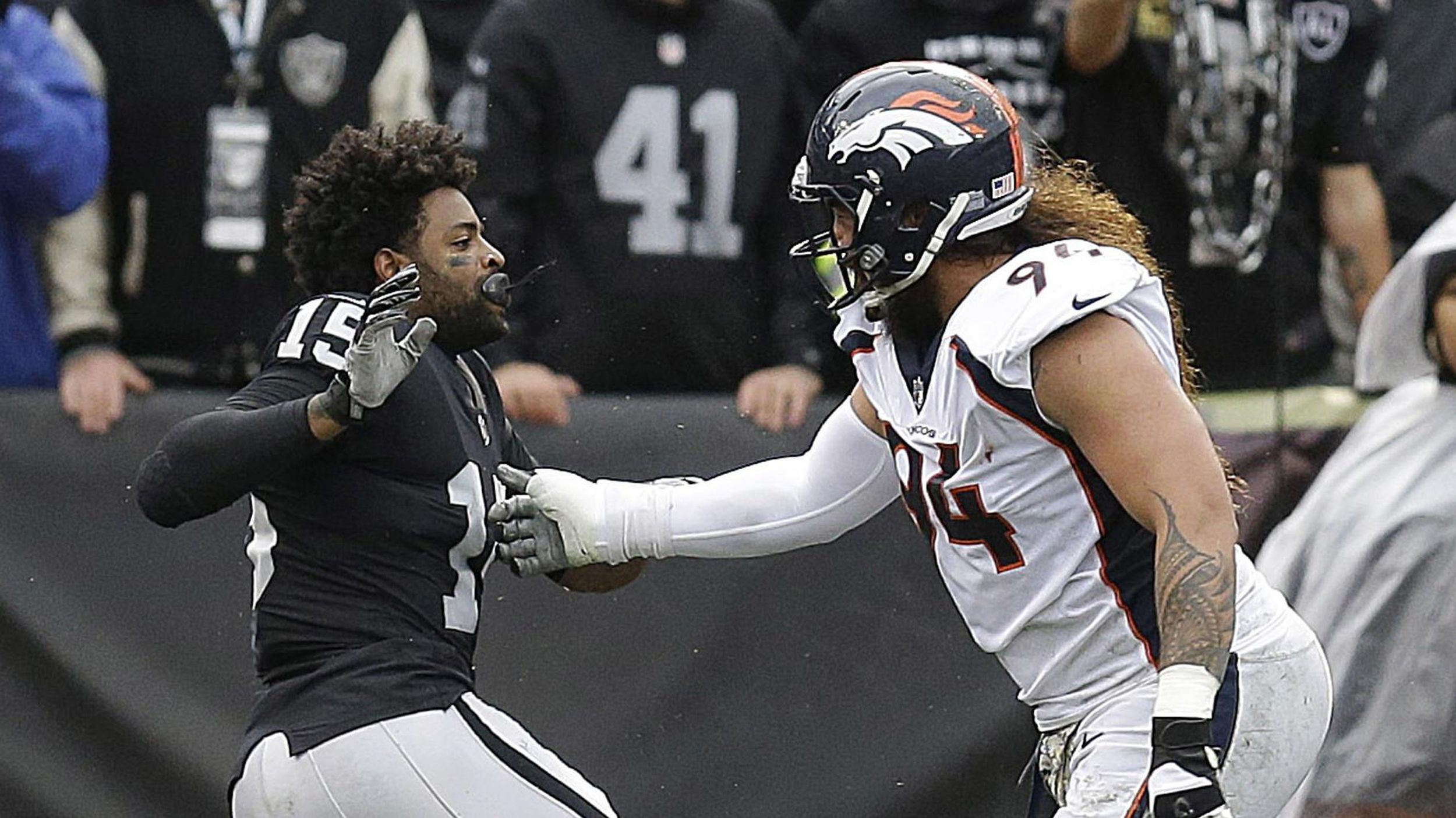 Michael Crabtree of the Oakland Raiders fights with Aqib Talib of