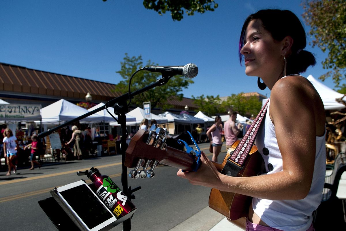 Coeur d'Alene singer/song writer Carli Osika entertained the crowd at the annual Street Fair in Coeur d'Alene on July 31, 2015. This weekend events include Taste of Coeur d’Alene happening in nearby City Park, the annual downtown Street Fair taking over Sherman Avenue. (Kathy Plonka / The Spokesman-Review)