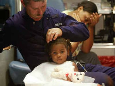 
A member of the Mobile Fire Department's Urban Search And Rescue team pulls grass out of Da'jour McMillan's hair as the child's mother, Mica Wilson, holds her head Monday, in Frisco City, Ala., after child was rescued from a 14-foot well. 
 (Associated Press / The Spokesman-Review)