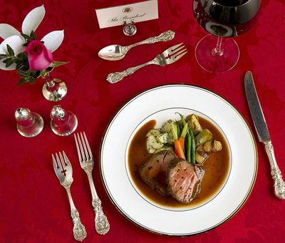 A White House holiday dinner from December 2004 features roast tenderloin of Angus beef, black truffle-scented merlot sauce, sautéed bulb onions, herb potatoes, green beans, baby carrots and artichokes.