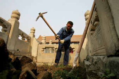 
A worker digs up old cobblestones at the entrance to the Hall of Military Eminence at the Forbidden City Thursday in Beijing.
 (Associated Press / The Spokesman-Review)