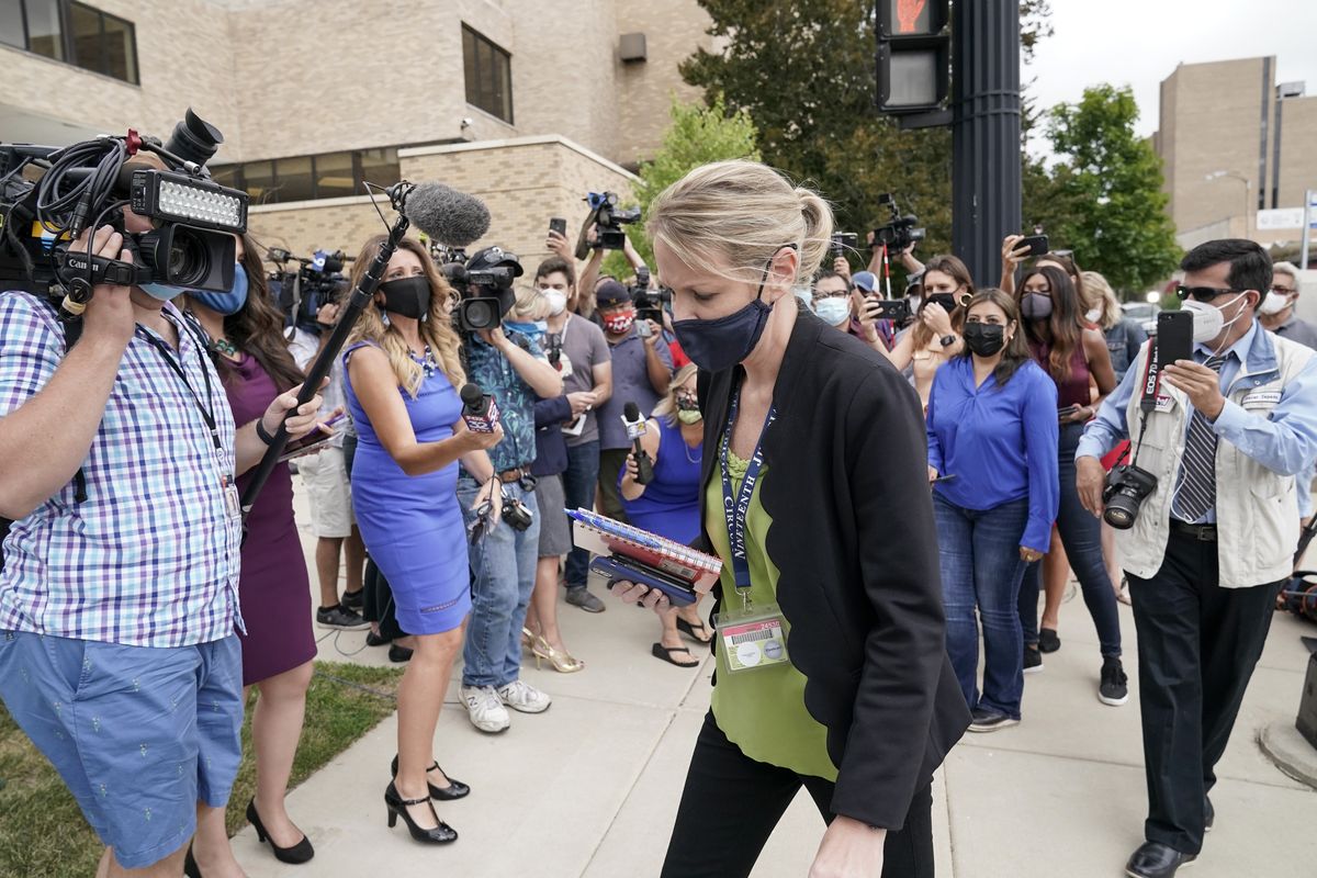 Kasey Morgan, a public information officer for the Lake County Court, walks away from reporters outside the Lake County courthouse following the extradition hearing for Kyle Rittenhouse Friday, Aug. 28, 2020, in Waukegan, Ill. A judge agreed Friday to delay for a month a decision on whether the 17-year-old from Illinois should be returned to Wisconsin to face charges accusing him of fatally shooting two protesters and wounding a third during a night of unrest following the weekend police shooting of Jacob Blake in Kenosha.  (Morry Gash)