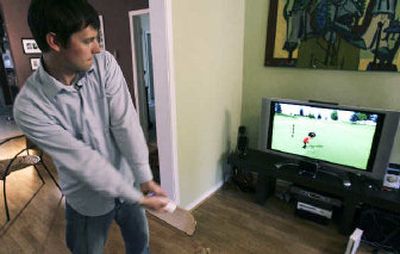 
Associated Press Technology Writer Matt Slagle demonstrates a golf swing while reviewing the Nintendo Wii game console.
 (Associated Press photos / The Spokesman-Review)