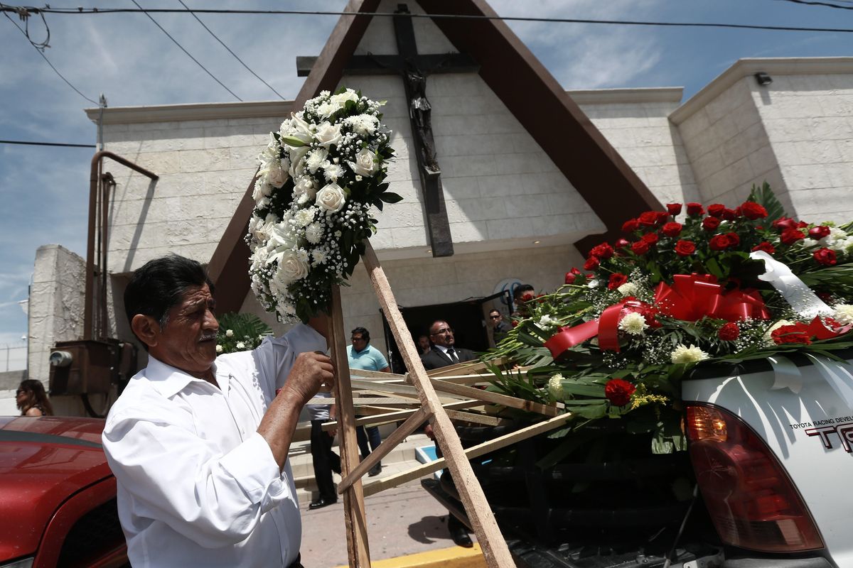 A man unloads funeral wreaths for a memorial service for Ivan Manzano, who was killed in the El Paso mass shooting, outside the Perches funeral home in Ciudad Juarez, Mexico, Friday, Aug. 9, 2019. Families of those killed when a gunman opened fire at an El Paso Walmart are gathering at funerals on each side of the U.S.-Mexico border to remember loved ones. (Christian Chavez / Associated Press)
